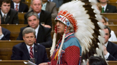 Assembly of First Nations Chief Phil Fontaine (right, wearing headdress) responds to the government’s apology