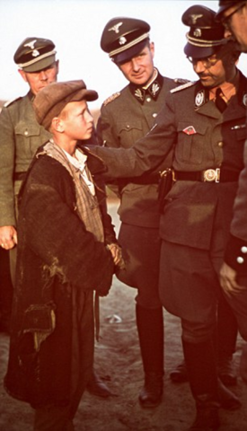 A rehomed child from Poland, Kostja Pablowitsch Harelek is pictured being inspected by SS chief Heinrich Himmler